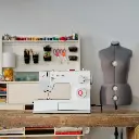 5523-singer-domestic-sewing-machine-on-wooden-table-with-sewing-equipment-behind.webp